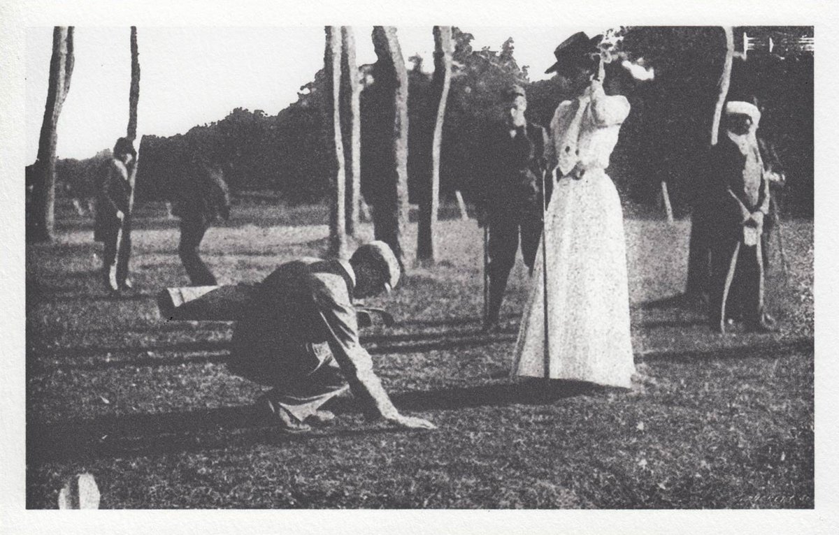 Photographie ancienne de joueuses en robe longue sur un parcours, l'une penchée sur sa balle
